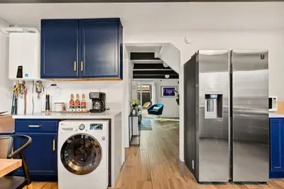 a kitchen with blue cabinets and a washer and a refrigerator at Hearthmoon Haven in Big Bear Lake