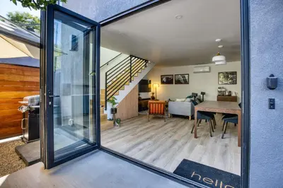 a view of a living room and dining room with a sliding glass door at Brand-New MCM Guesthouse in West Los Angeles in Los Angeles