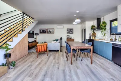 a kitchen and living room with a table and chairs at Brand-New MCM Guesthouse in West Los Angeles in Los Angeles