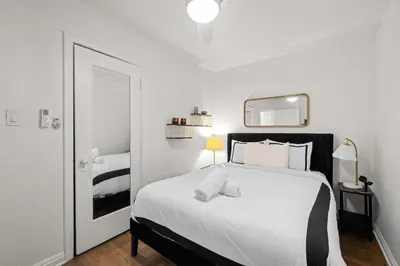 a white bedroom with a bed and a mirror at Remodeled 1BR LA Apartment with full kitchen in Los Angeles