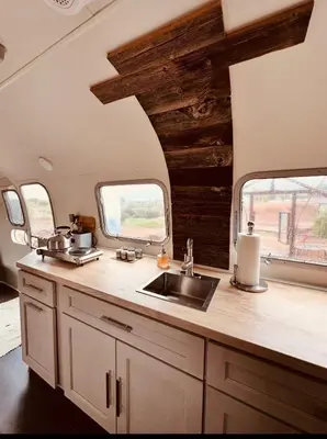 a kitchen in an rv with a sink and two windows at Zaromelranch