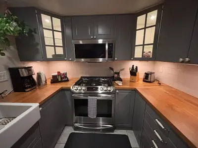 a kitchen with black cabinets and a stove at Lakeview Location Hot tub Tesla Charger tree house in Big Bear Lake