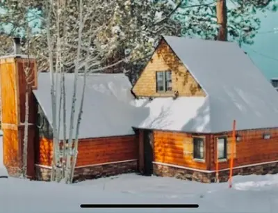 a small house with snow on the roof at Lakeview Location Hot tub Tesla Charger tree house in Big Bear Lake