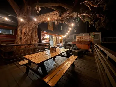 a wooden table in a room with a tree at Lakeview Location Hot tub Tesla Charger tree house in Big Bear Lake