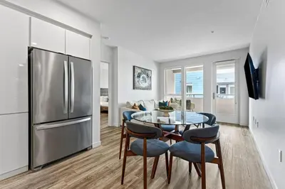 a kitchen with a table and a stainless steel refrigerator at Nautical Knees Water View Pool, Jacuzzi and Gym in Los Angeles