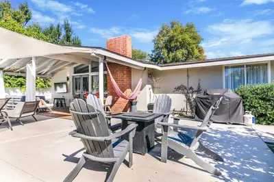 a patio with a table and chairs on a patio at SoCal Retreat with Pool and Spacious Backyard in Canoga Park
