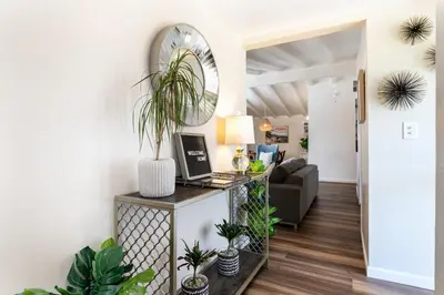 a living room with a desk with a laptop and plants at SoCal Retreat with Pool and Spacious Backyard in Canoga Park