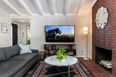 a living room with a couch and a tv at SoCal Retreat with Pool and Spacious Backyard in Canoga Park