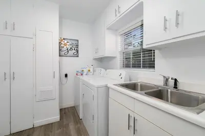 a white kitchen with white cabinets and a sink at Valley Oasis Pool Hot Tub Near Universal in Garnsey