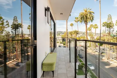a balcony with a green bench and palm trees at Abracadabra Ultra Luxury Private Residence in Los Angeles