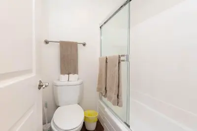 a bathroom with a toilet and a glass shower at Cozy 2BR Near Disneyland and Convention Center in Anaheim