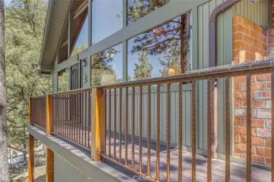 a front porch of a home with a metal railing at Pet Friendly 3BR Pine Mountain Club Cabin with King Bed and Pool Access in Pine Mountain Club