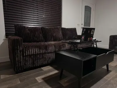 a living room with a couch and a table with a laptop at Brick & Breeze in Bakersfield