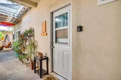 a white door in a building with a side table at Explore Shops, Eats and Entertainment! Pasadena Apt in Pasadena