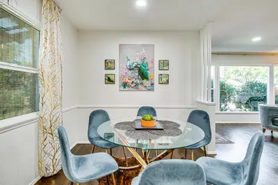 a dining room with a glass table and blue chairs at Peacock House Sanctuary 4 Mi to Old Pasadena! in Pasadena