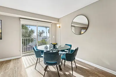 a dining room with a table and chairs and a mirror at Vertical Blue Bi-Level Sanctuary with Pacific Vistas in Los Angeles