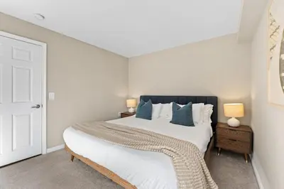 a bedroom with a large white bed with blue pillows at Vertical Blue Bi-Level Sanctuary with Pacific Vistas in Los Angeles