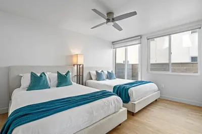 a bedroom with two beds and a ceiling fan at Urban Tide - A Designer Escape Overlooking the Docks in Los Angeles