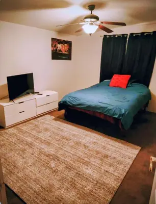 a bedroom with a bed and a dresser with a tv at The Joshua House in Boron