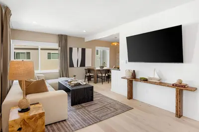 a living room with a couch and a flat screen tv at The Drift Manhattan Beach - steps to the ocean in Manhattan Beach