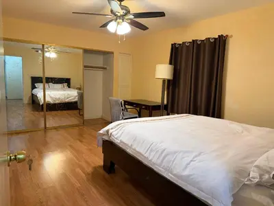 a bedroom with a bed with a ceiling fan and a mirror at Citrus Loft Room B - Quiet and Convenience Female Only in Covina