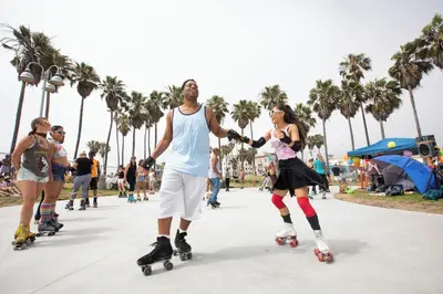 a man and woman riding skateboards down a sidewalk at The Zenith Penthouse - Ocean Panoramas & Salt Air in Los Angeles