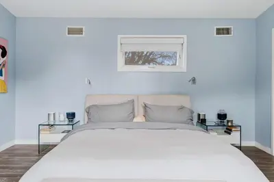 a bedroom with a large white bed with two tables at New Listing West LA Urban Oasis by Colby & Conrad in Los Angeles