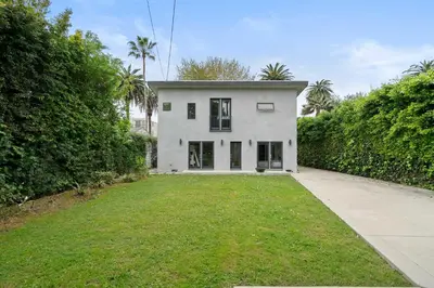 a white house with a large yard at New Listing West LA Urban Oasis by Colby & Conrad in Los Angeles