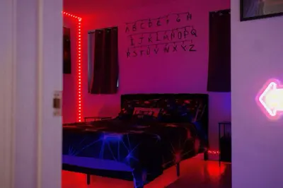 a bedroom with a bed with neon lights at Themed Townhouse Retreat Near LAX and Sofi in Los Angeles