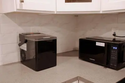 a microwave and a toaster oven sitting on a kitchen counter at Themed Townhouse Retreat Near LAX and Sofi in Los Angeles
