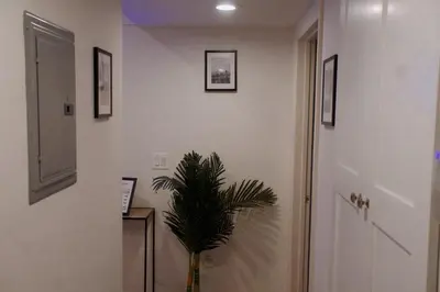 a hallway with a plant in a vase next to a door at Themed Townhouse Retreat Near LAX and Sofi in Los Angeles