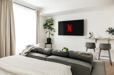 a living room with a couch and a n on the wall at Platinum Space in WeHo in Los Angeles