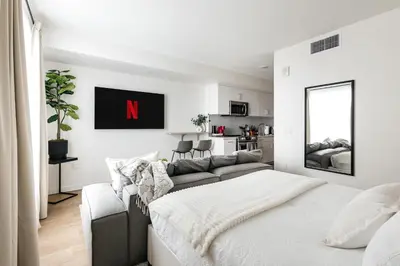 a white bedroom with a large bed and a couch at Platinum Space in WeHo in Los Angeles