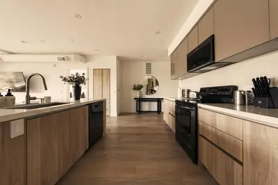 a kitchen with wooden cabinets and a counter top at The Velvet Coast - Grand 3BR Artistic Haven in Los Angeles