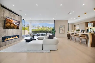 a living room with white furniture and a fireplace at Amestoy Modern in Los Angeles