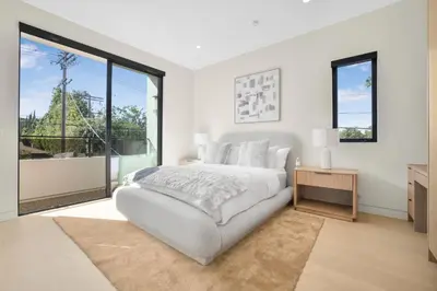 a white bedroom with a bed and a large window at Amestoy Modern in Los Angeles