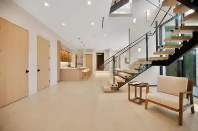 a living room with a staircase and a chair at Amestoy Modern in Los Angeles