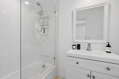 a white bathroom with a shower and a sink at Beverly Hills Canyon Estate by Colby & Conrad in Los Angeles