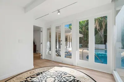 a living room with white walls and a pool at Beverly Hills Canyon Estate by Colby & Conrad in Los Angeles
