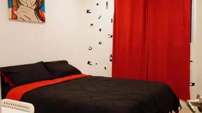 a bedroom with a bed and a red curtain at Pop Art Themed Bedroom in House-Shared Bathroom-Shared Living Room & Kitchen in Los Angeles