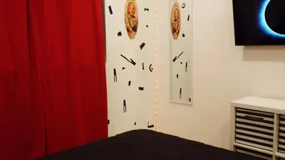 a bedroom with a wall with clocks on it at Pop Art Themed Bedroom in House-Shared Bathroom-Shared Living Room & Kitchen in Los Angeles