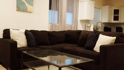 a living room with a brown couch and a glass table at Pop Art Themed Bedroom in House-Shared Bathroom-Shared Living Room & Kitchen in Los Angeles