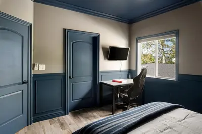 a bedroom with a bed and a desk and a window at Sherman Oaks Home w Pool, Spa and Outdoor Kitchen in Los Angeles