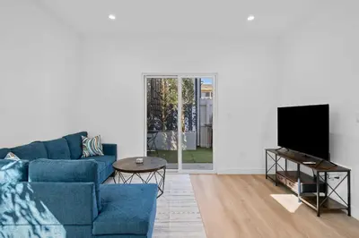 a living room with a blue couch and a tv at New Listing Iconic Venice Living by Colby & Conrad in Los Angeles