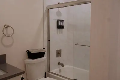 a bathroom with a toilet and a glass shower at The Sunset Gathering in Los Angeles