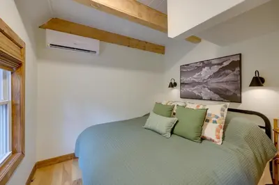 a bedroom with a green bed with pillows at 1 Mi to Lake Arrowhead! All-Season Family Getaway in Lake Arrowhead
