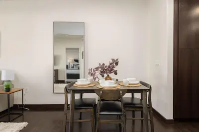 a dining room table with chairs and a mirror at West Hollywood Chic Apartment in Los Angeles