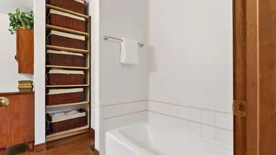 a white bath tub in a bathroom with baskets at Holiday Lake Cabin by AvantStay Large Deck Cozy Fireplace Near Arrowhead Village in Lake Arrowhead