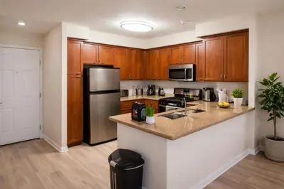 a kitchen with wooden cabinets and a stainless steel refrigerator at Marina 1-Bedroom & 2-Bedroom - Near Venice Beach & Marina in Los Angeles
