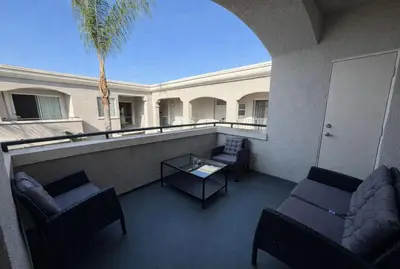 a balcony with couches and a table and a palm tree at Marina Breeze Retreat 2BR 2BA - Close To Venice Beach in Los Angeles